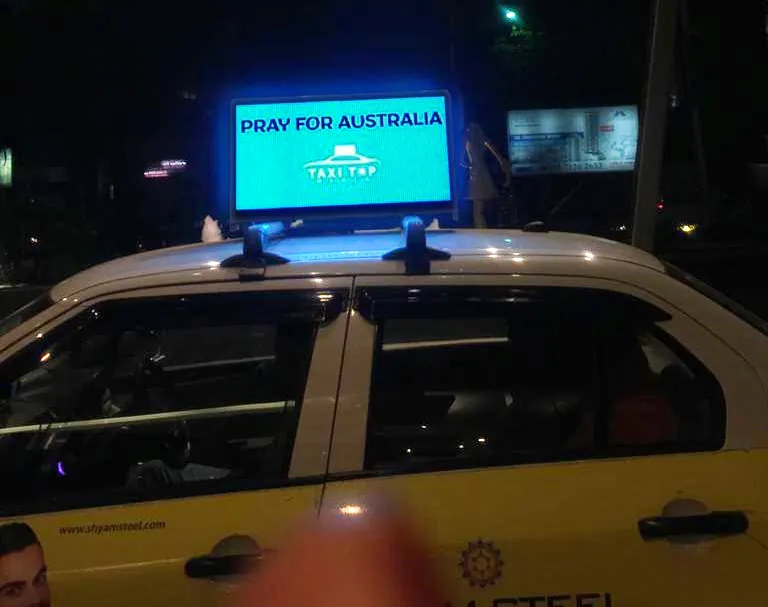 Lit LED taxi-top on a yellow cab at night